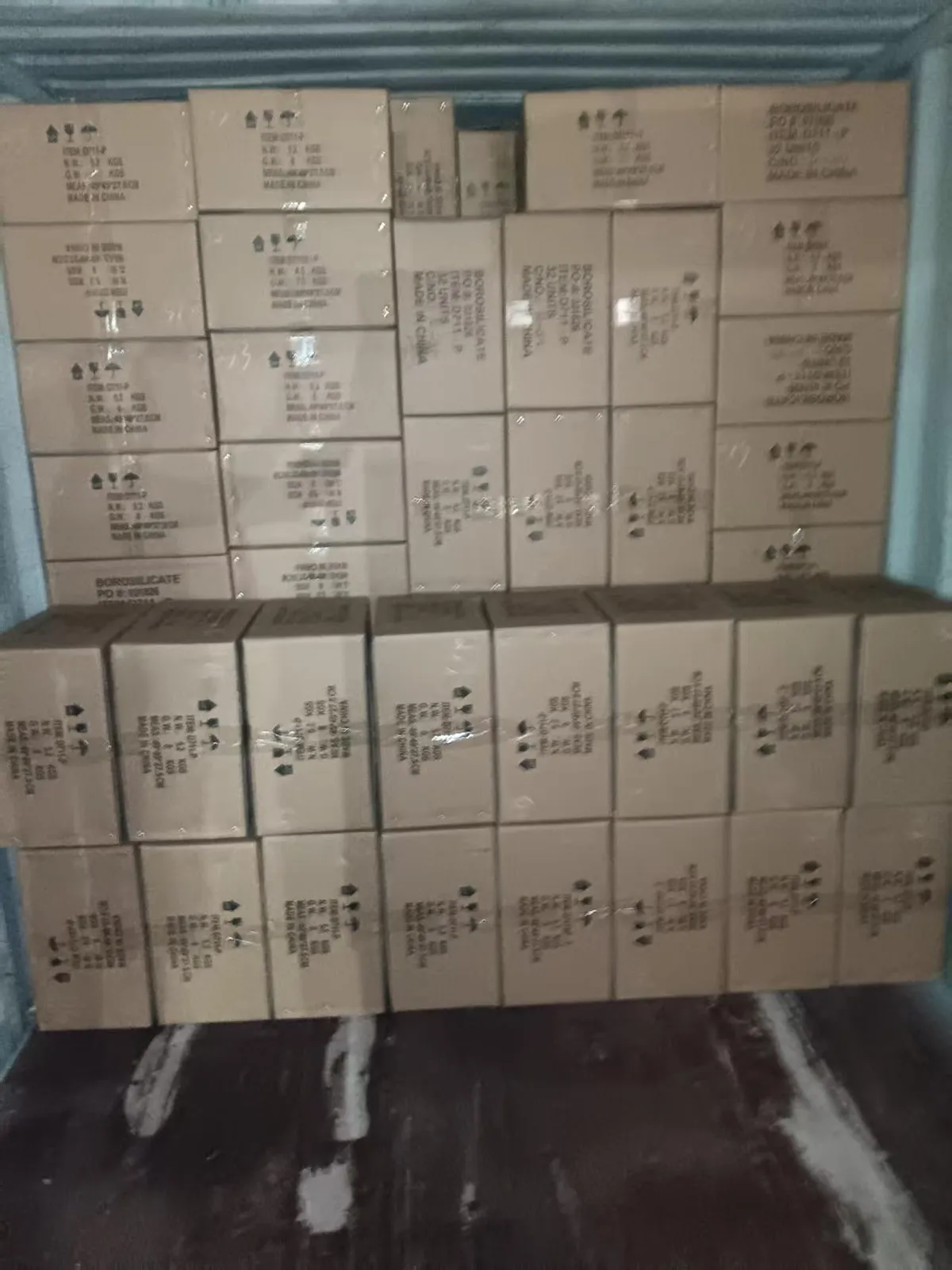 Fig 1: Palletized glassware cartons at the Yantian loading point — corrugated cartons with individual cell dividers inside